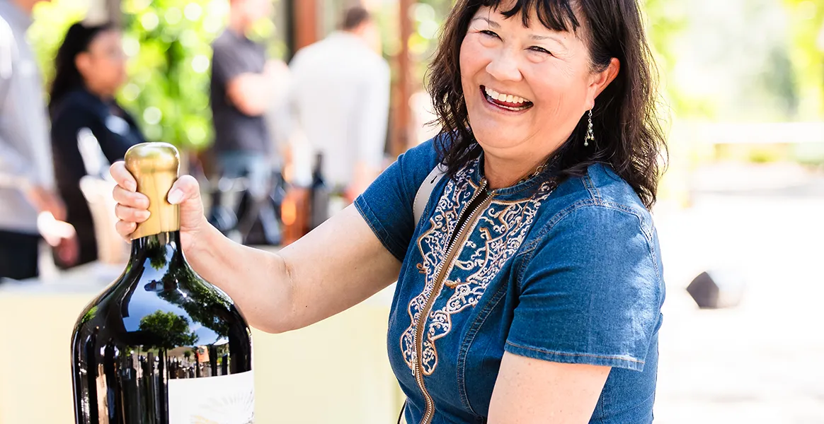 Happy Lady with a huge bottle of Somerston red wine.