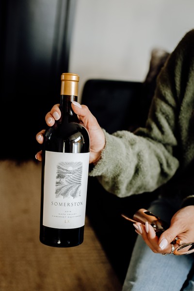 Person holding up a bottle of Somerston Estate wine