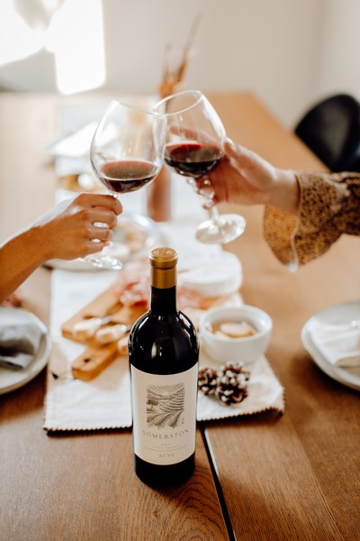 People toasting glasses of Somerston Estate wine at a table